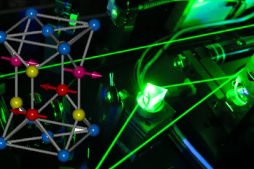 Schematics and an antiferromagnetic crystal on a background with laser beams.