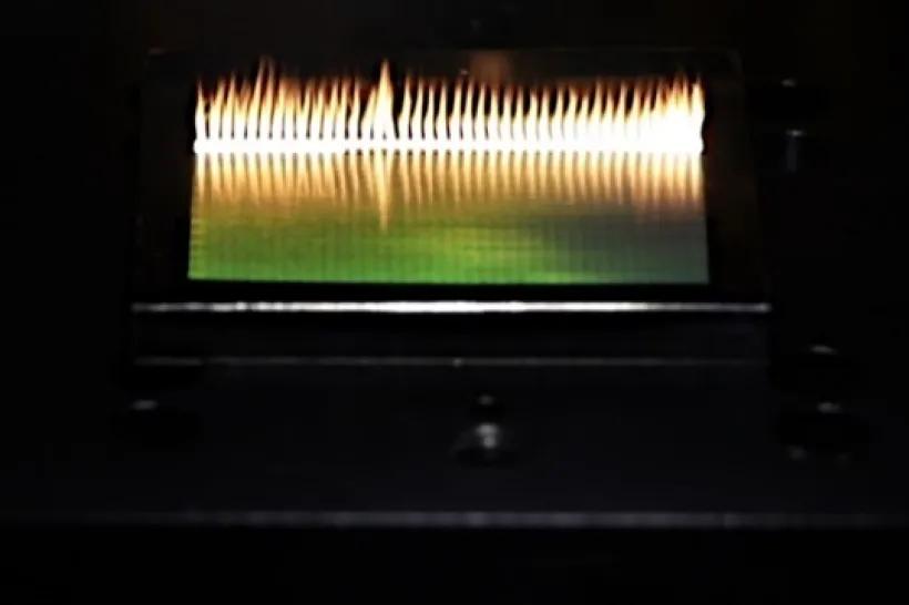 (a) Fotografie z průběhu procesu při ozáření 200 W průměrného výkonu a detailní pohled na vytvořenou nanostrukturu s periodiou (b) 400 nm a (c) 900 nm